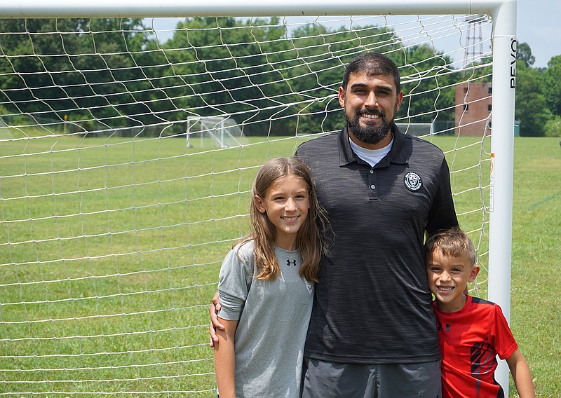 Hot Springs Soccer Association President Edgardo Argueta stands with his daughter Jasmyn and son Jackson on one of the soccer fields at Munro Soccer Complex. The Sentinel-Record/Krishnan Collins