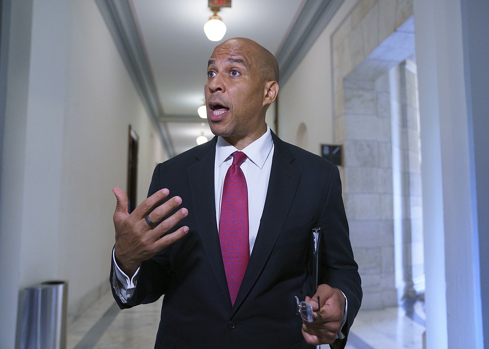 Sen. Cory Booker, D-N.J., speaks to reporters as the Senate Commerce, Science, and Transportation Committee holds a hearing on student athlete compensation and federal legislative proposals to enable athletes participating in collegiate sports to monetize their name, image, and likeness, at the Capitol in Washington, Wednesday, June 9, 2021. (AP Photo/J. Scott Applewhite)