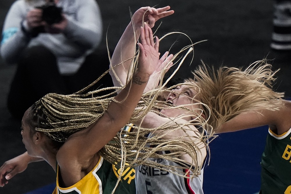FILE - In this March 29, 2021, file photo, Baylor's DiJonai Carrington, left, shoots past Connecticut's Paige Bueckers during the second half of an NCAA college basketball game in the Elite Eight round of the NCAA college basketball tournament at the Alamodome in San Antonio. Connecticut has become the latest state to pass legislation allowing college athletes to make a profit from their names, images and likenesses. The language, which received final approval in the Senate late Tuesday, June 8, 2021, makes it possible for college players to be paid for endorsements, social media content, sponsorship deals and personal appearances. (AP Photo/Morry Gash, File)