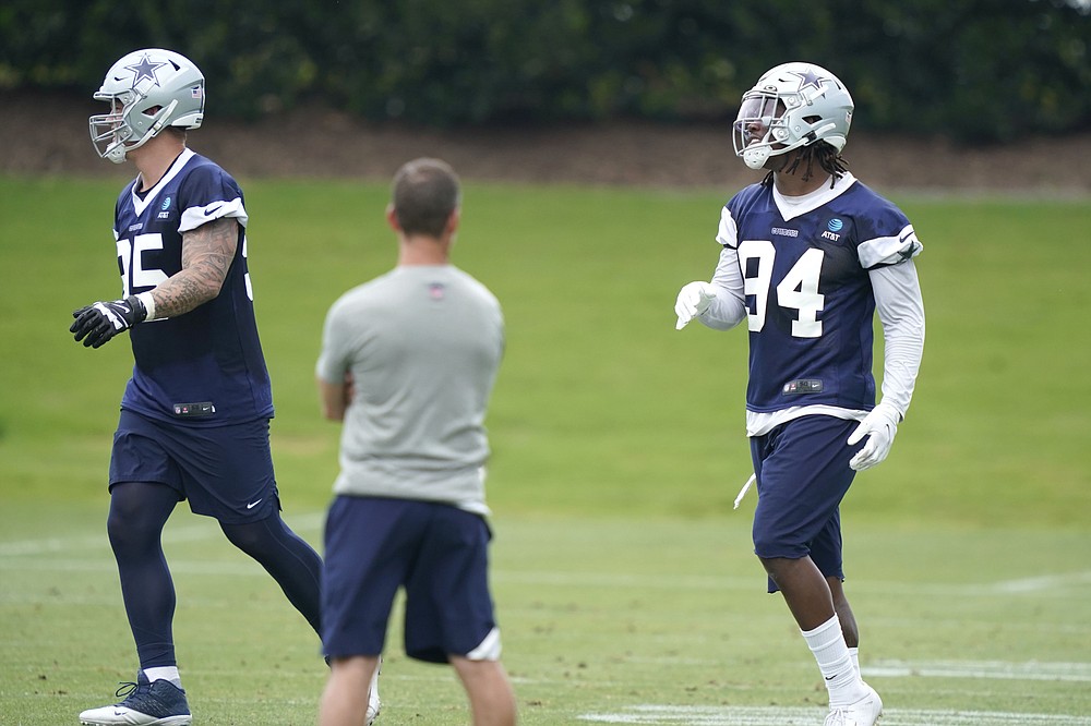 Dallas Cowboys defensive end Randy Gregory (94) runs drills with teammate Brent Urban (85) during an NFL football team practice Wednesday, June 9, 2021, in Frisco, Texas. Gregory isn't ashamed of a suspension-filled past that nearly derailed his NFL career, just maybe a little tired of it being the focus of his story. (AP Photo/LM Otero)