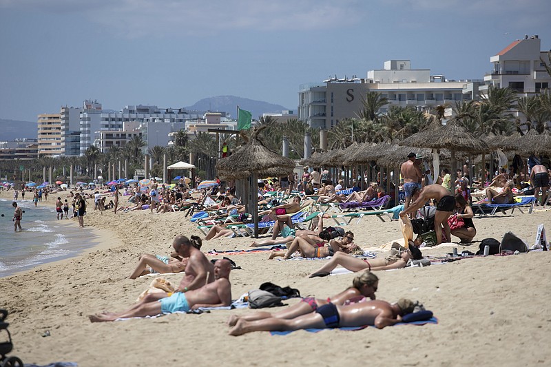 Tourists sunbathe on the beach at the Spanish Balearic Island of Mallorca, Spain, Monday, June 7, 2021. Spain is jumpstarting its summer tourism season by welcoming vaccinated visitors from most countries as well as European visitors who can prove they are not infected with coronavirus. It also reopened its ports to cruise ship stops on Monday. (AP Photo/Francisco Ubilla)