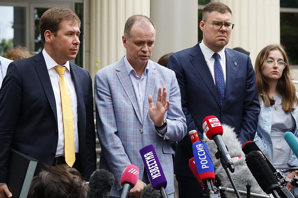 Russian lawyer Ivan Pavlov, center, gestures while speaking to the media as other lawyers stand around him during a break in a court session in front of Moscow Court, in Moscow, Russia, Wednesday, June 9, 2021. A court is expected to outlaw the organizations founded by Russian opposition leader Alexei Navalny. Prosecutors have asked the Moscow City Court to designate Navalny's Foundation for Fighting Corruption and his sprawling network of regional offices as extremist organizations. The extremism label also carries lengthy prison terms for activists who have worked with the organizations, anyone who donated to them, and even those who simply shared the groups' materials. (AP Photo/Alexander Zemlianichenko)