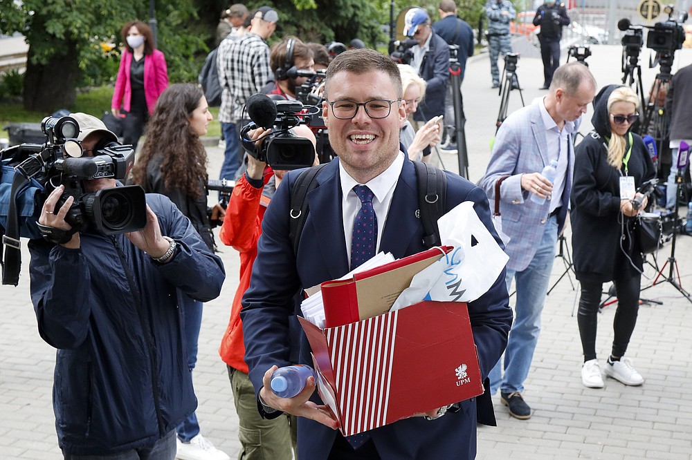 Russian lawyer Vladimir Voronin carries documents after a break in a court session in front of Moscow Court in Moscow, Russia, Wednesday, June 9, 2021. A court is expected to outlaw the organizations founded by Russian opposition leader Alexei Navalny. Prosecutors have asked the Moscow City Court to designate Navalny's Foundation for Fighting Corruption and his sprawling network of regional offices as extremist organizations. The extremism label also carries lengthy prison terms for activists who have worked with the organizations, anyone who donated to them, and even those who simply shared the groups' materials. (AP Photo/Alexander Zemlianichenko)
