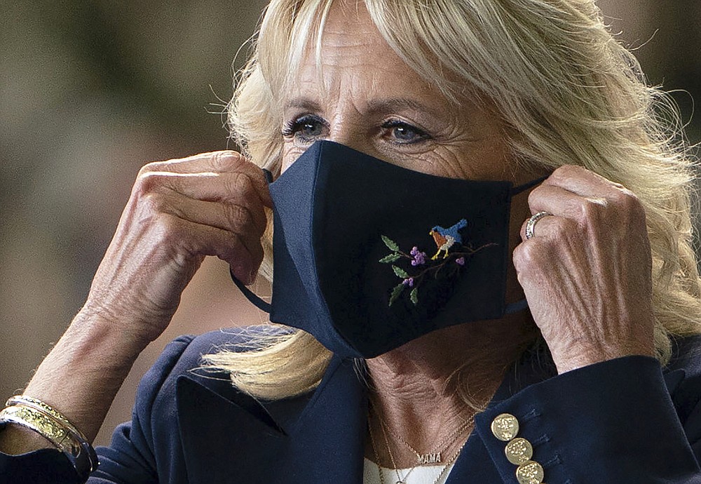 First lady Jill Biden adjusts her face mask after addressing U.S. Air Force personnel at RAF Mildenhall in Suffolk, England, ahead of the G7 summit in Cornwall, Wednesday, June 9, 2021. (Joe Giddens/Pool via AP)