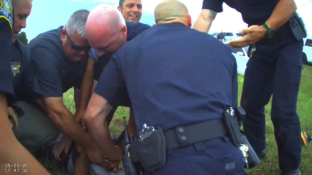 In this Saturday, May 23, 2020 image from Franklin Parish Sheriff's Office body camera video, law enforcement officers restrain motorist Antonio Harris, bottom center, on the side of a road after a high speed chase in Franklin Parish, La. (Aaron Touchet/Franklin Parish Sheriff's Office via AP)