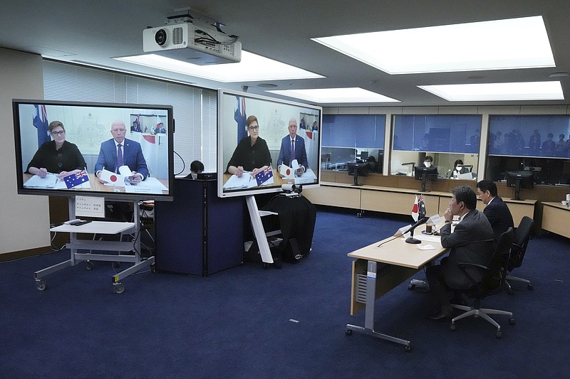 Japanese Foreign Minister Toshimitsu Motegi, second right, and Defense Minister Nobuo Kishi, right, attend a video conference with Australian Foreign Minister Marise Payne, left on screen, and Australian Defense Minister Peter Dutton, right on screen, at Foreign Ministry in Tokyo during their two-plus-two ministerial meeting Wednesday, June 9, 2021, in Tokyo. (AP Photo/Eugene Hoshiko, Pool)