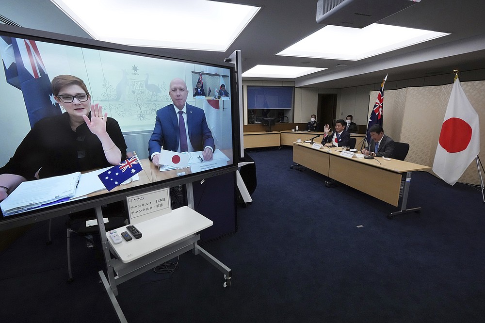 Japanese Foreign Minister Toshimitsu Motegi, right, and Defense Minister Nobuo Kishi, second right, attend a video conference with Australian Foreign Minister Marise Payne, left on screen, and Australian Defense Minister Peter Dutton, right on screen, at Foreign Ministry in Tokyo during their two-plus-two ministerial meeting Wednesday, June 9, 2021, in Tokyo. (AP Photo/Eugene Hoshiko, Pool)