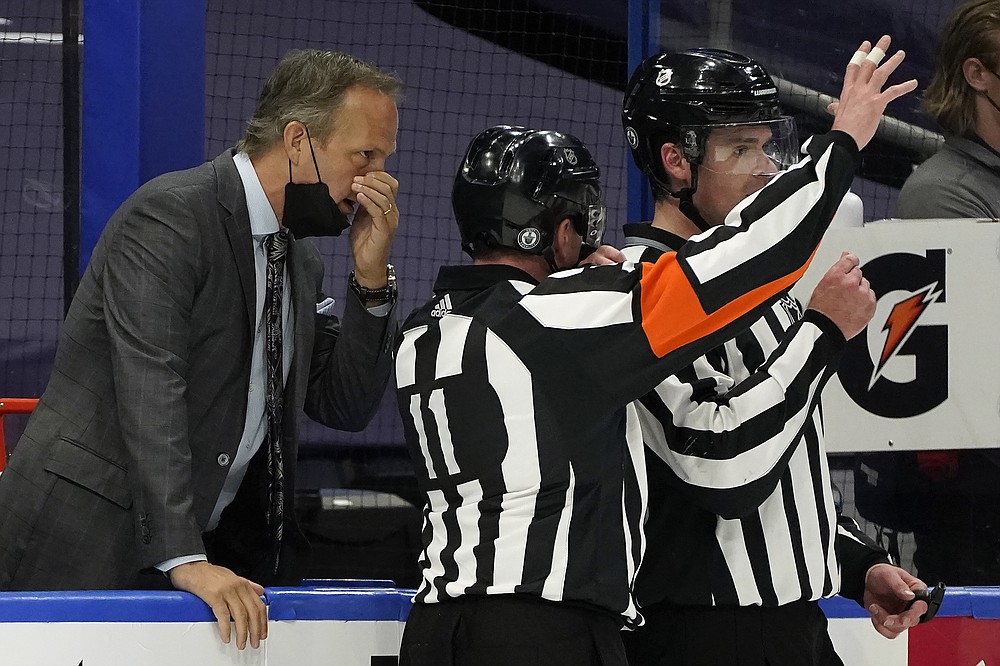 Tampa Bay Lightning head coach Jon Cooper talks to referee Kelly Sutherland (11) during the second period in Game 4 of an NHL hockey Stanley Cup first-round playoff series against the Florida Panthers Saturday, May 22, 2021, in Tampa, Fla. (AP Photo/Chris O'Meara)