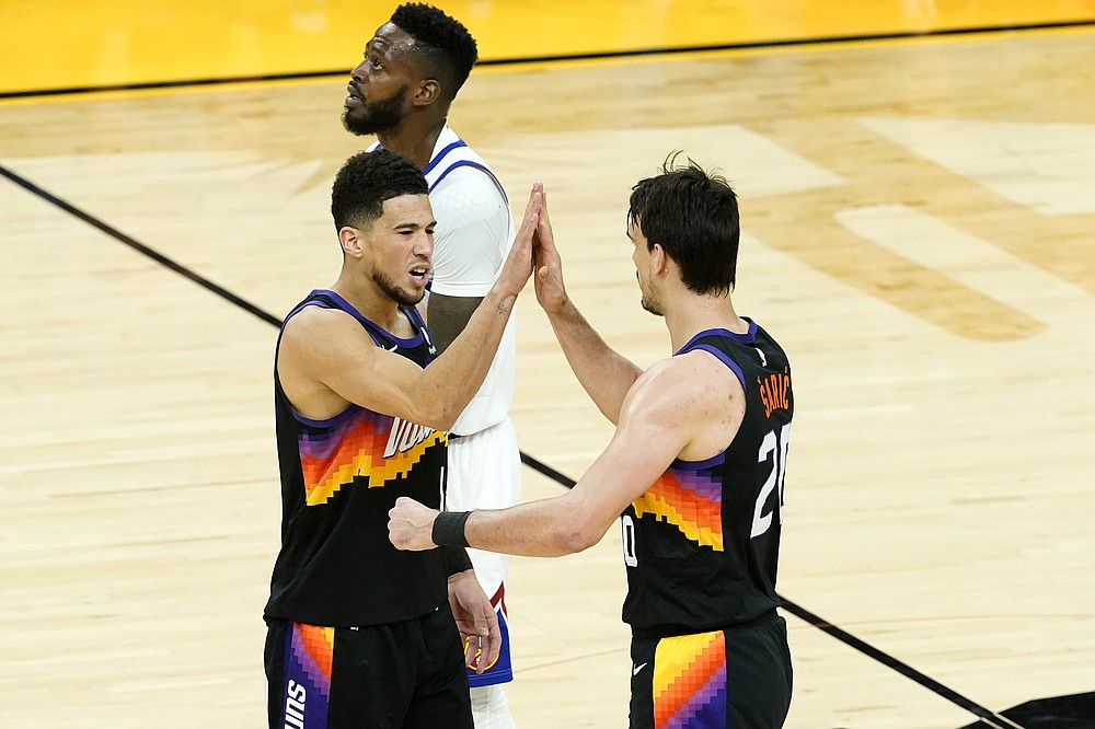 Phoenix Suns guard Devin Booker, left, high fives forward Dario Saric after a three pointer against the Denver Nuggets during the first half of Game 2 of an NBA basketball second-round playoff series, Wednesday, June 9, 2021, in Phoenix. (AP Photo/Matt York)