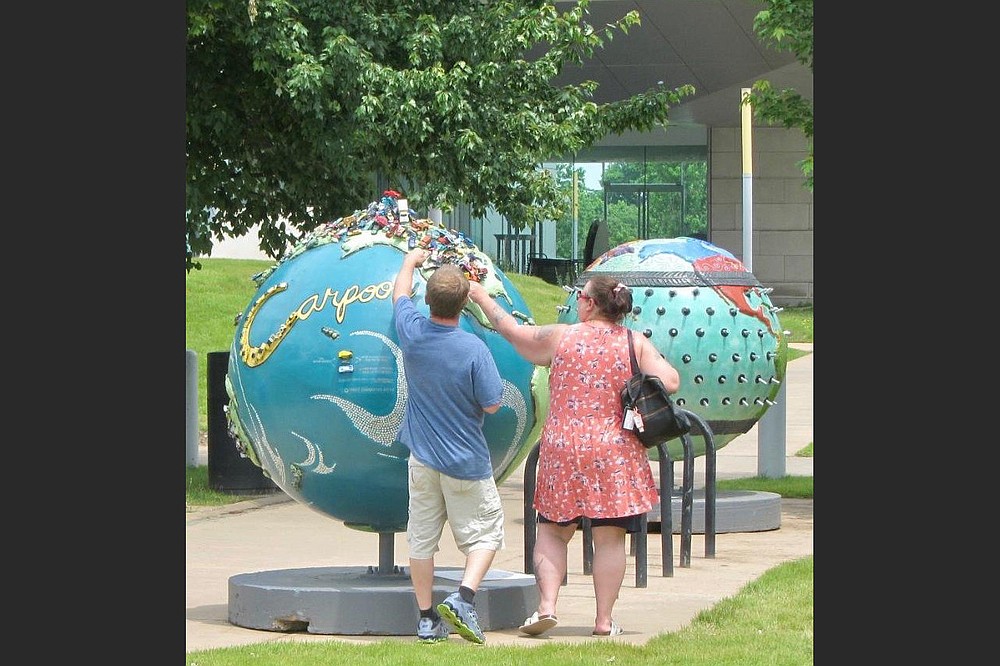 The “Cool Globes” exhibit includes Cheryl Steiger’s “Carpool” (left) and Derric Clemmons’ “Under Pressure.” (Special to the Democrat-Gazette/Marcia Schnedler)