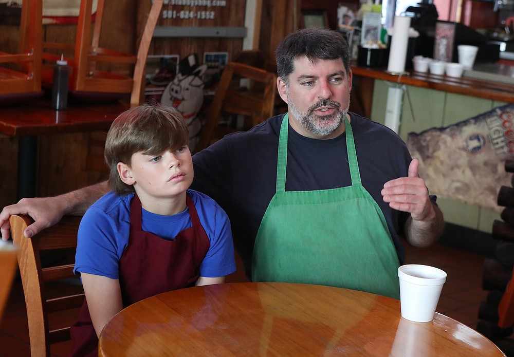 Palmer Dunkel, left, is growing up in the family business much like his father Chris Dunkel, right, did at Stubby’s BBQ. - Photo by Richard Rasmussen of The Sentinel-Record