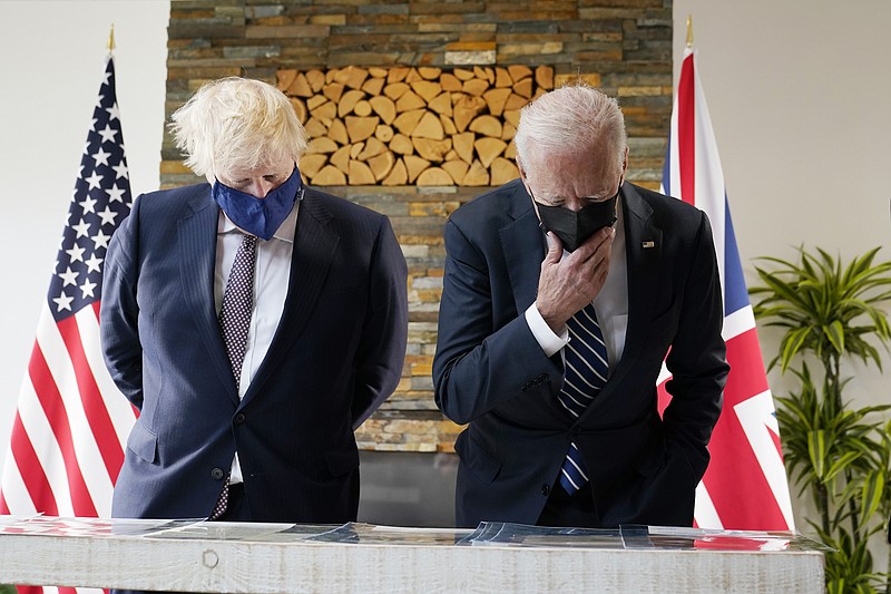 President Joe Biden and British Prime Minister Boris Johnson look at copies of the Atlantic Charter, during a bilateral meeting ahead of the G-7 summit, Thursday, June 10, 2021, in Carbis Bay, England.The Atlantic Charter is a copy of the original 1941 statement signed by FDR and Winston Churchill. (AP Photo/Patrick Semansky)