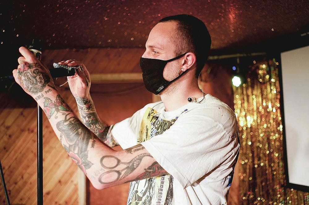 El músico Iacopo Bertelli, nombre artístico Jack Milwaukee, desinfecta su micrófono antes de su actuación en vivo en el Moth Club en Hackney, Londres, el domingo 30 de mayo de 2021. El regreso de la música en vivo en la ciudad que produjo bandas de los Rolling Stones to the Spice Girls ha reavivado la creatividad de algunos de los muchos artistas que trabajan en Londres después de 14 meses de silencio. (Foto AP / Alberto Pezzali)