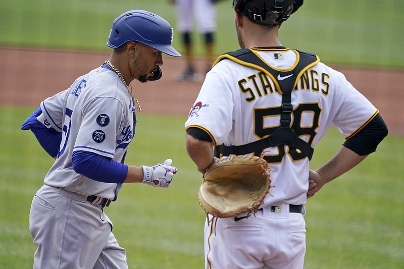 Los Angeles Dodgers' Mookie Betts, left, crosses home plate past Pittsburgh Pirates catcher Jacob Stallings after hitting a solo home run during the first inning of a baseball game in Pittsburgh, Thursday, June 10, 2021. (AP Photo/Gene J. Puskar)