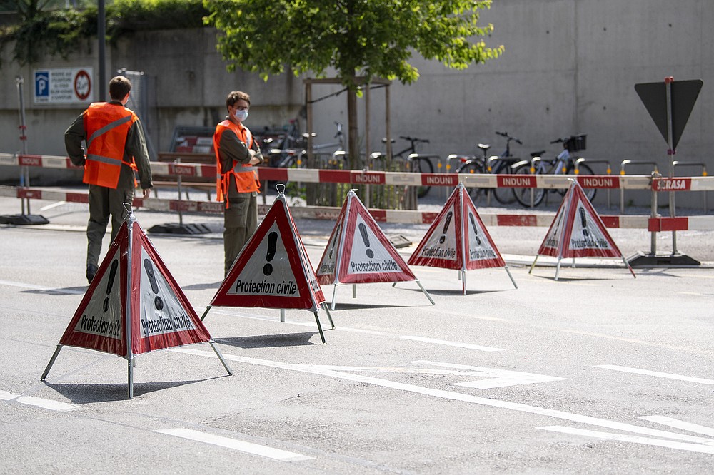 Members of the civil protection block access to a street in order to install fences outside the Parc La Grange aux Eaux-Vives in Geneva, Switzerland, Wednesday, June 09, 2021. The "Villa La Grange" is the possible but yet unconfirmed venue of the meeting between US president Joe Biden and Russian presidents Vladimir Putin in Geneva, scheduled on Wednesday June 16, 2021. (Martial Trezzini/Keystone via AP)