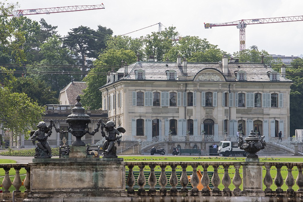 People stay in front of the "Villa La Grange" in the Parc La Grange at the Eaux-Vives in Geneva, Switzerland, Wednesday, June 09, 2021. The "Villa La Grange" is the possible but yet unconfirmed venue of the meeting between US president Joe Biden and Russian presidents Vladimir Putin in Geneva, scheduled on Wednesday June 16, 2021. (Martial Trezzini/Keystone via AP)