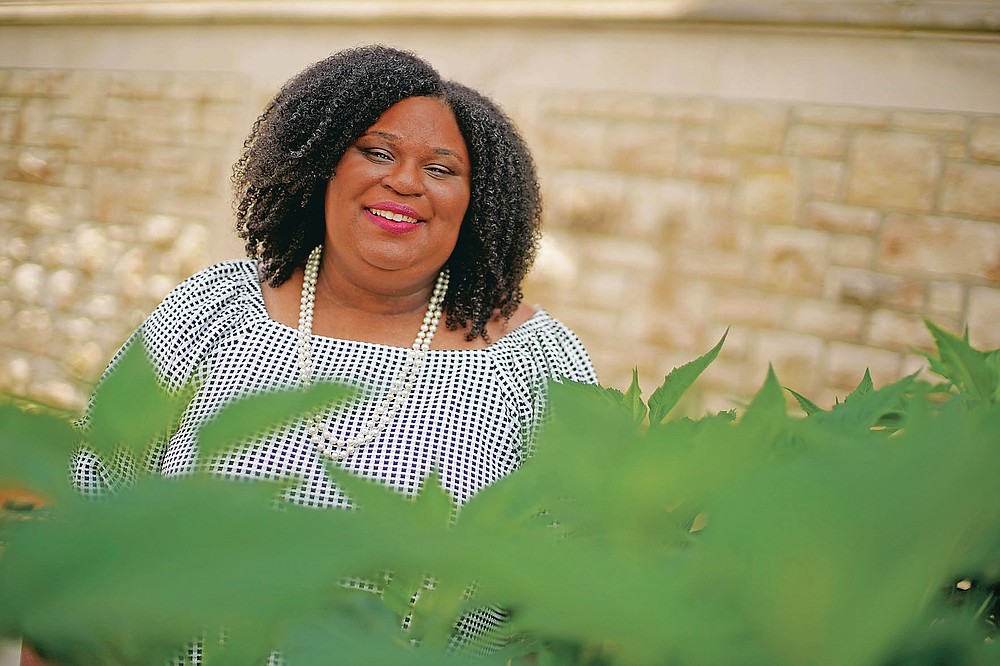 Emily Brown poses in a garden outside her office Wednesday, June 9, 2021, in Kansas City, Mo. Brown runs a nonprofit service to help families with food allergies access safe and healthy foods which she started after having difficulty obtaining food for her daughters who have numerous food allergies. (AP Photo/Charlie Riedel)