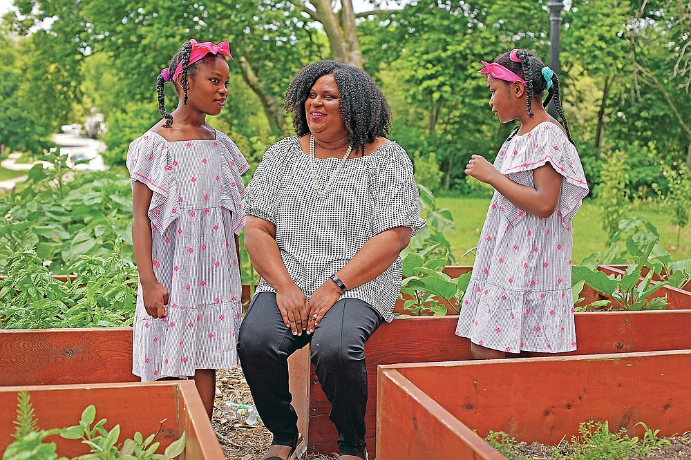 Emily Brown talks with her daughters Hannah, 7, left, and Catherine, 9, outside her office Wednesday, June 9, 2021, in Kansas City, Mo. Brown runs a nonprofit service to help families with food allergies access safe and healthy foods which she started after having difficulty obtaining food for her daughters who have numerous food allergies. (AP Photo/Charlie Riedel)
