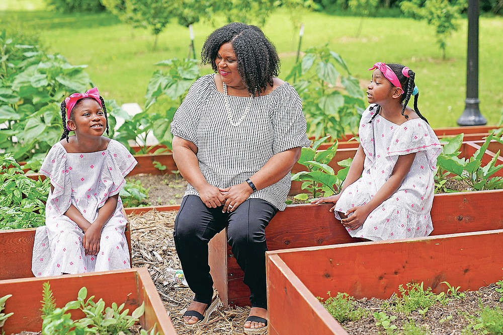 Emily Brown talks with her daughters Hannah, 7, left, and Catherine, 9, outside her office Wednesday, June 9, 2021, in Kansas City, Mo. Brown runs a nonprofit service to help families with food allergies access safe and healthy foods which she started after having difficulty obtaining food for her daughters who have numerous food allergies. (AP Photo/Charlie Riedel)