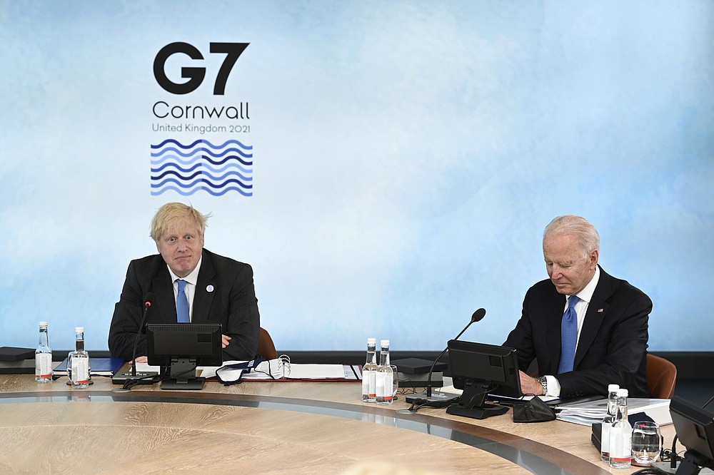 Il primo ministro britannico Boris Johnson, a sinistra, e il presidente degli Stati Uniti Joe Biden siedono attorno al tavolo al vertice della riunione del Gruppo dei Sette, a Carbis Bay, in Cornovaglia, in Inghilterra, venerdì 11 giugno 2021 (Leon Neal/Pool Photo via AP)