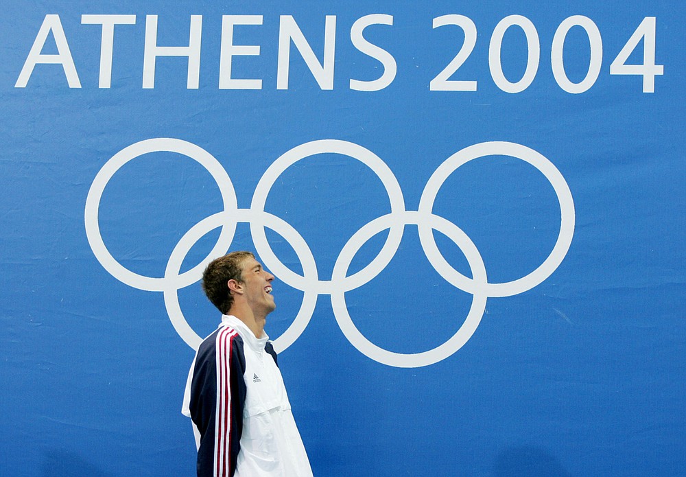 FILE - In this Aug. 14, 2004, file photo, Michael Phelps, of the United States, smiles after his win in the 400-meter individual medley at the Olympic Games in Athens, Greece. For the first time since 1996, the U.S. Olympic swimming trials are being held without the sport's biggest star, the guy who won a staggering 23 gold medals and 28 medals overall at the Olympics. (AP Photo/Mark Baker, File)