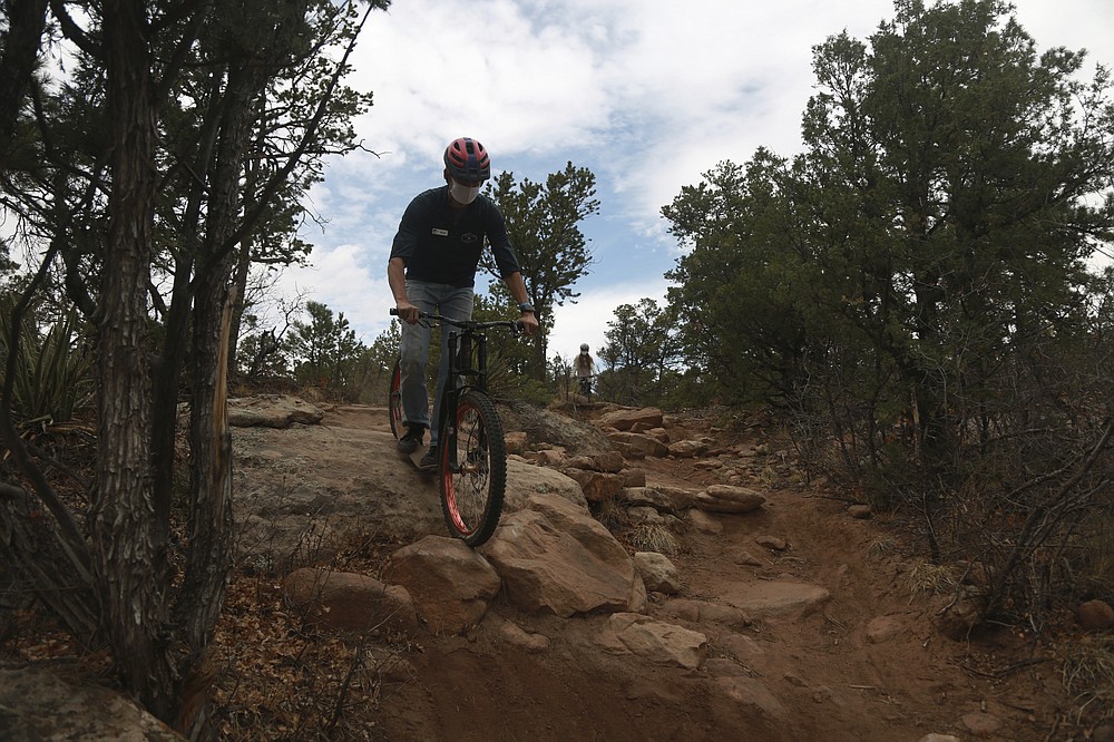 Glorieta Adventure Camp staff member Bryce Zeigle teaches counselors how to use an off-road scooter on Friday, May 21, 2021, in Glorieta, N.M. The 3,000-bed camp outside Santa Fe opened up at a third of its normal capacity under pandemic restrictions after being closed last year. Campers and staff will be kept in pods of 10 or less, wear masks outside their sleeping quarters, and eat outdoors to prevent outbreaks. (AP Photo/Cedar Attanasio)