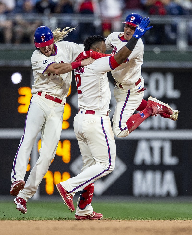 Philadelphia Phillies' Travis Jankowski, left, Jean Segura (2) and Ronald Torreyes, right, celebrate after the Phillies defeated the New York Yankees 8-7 in 10 innings in a baseball game Saturday, June 12, 2021, in Philadelphia. (AP Photo/Laurence Kesterson)