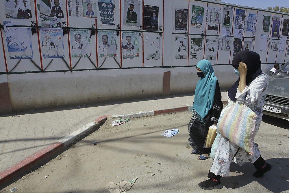 Des femmes défilent devant les affiches électorales à Ain El Oussara, à 190 km d'Alger, le jeudi 10 juin 2021. Outre les partis traditionnels, des dizaines de candidats indépendants ont décidé de participer aux élections législatives du 12 juin, dont le gouvernement organisé plus tôt que prévu Dans le cadre d'un nouveau système visant à éliminer la corruption et à ouvrir les listes électorales - une étape majeure dans la promesse du président Abdelmadjid Tebboune "nouvelles îles." (Presse associée/Fateh Ghaydom)