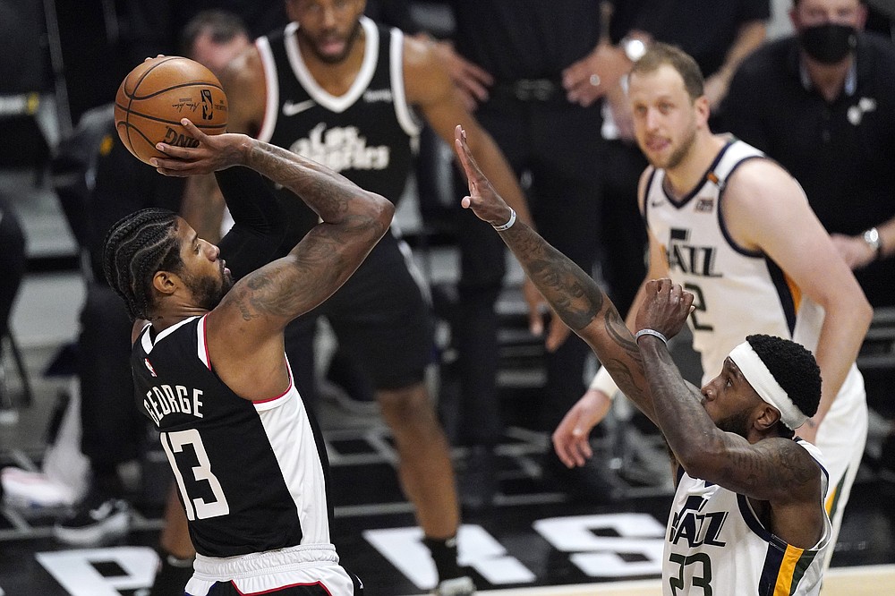 Los Angeles Clippers guard Paul George, left, shoots as Utah Jazz forward Royce O'Neale defends during the second half of Game 3 of a second-round NBA basketball playoff series Saturday, June 12, 2021, in Los Angeles. (AP Photo/Mark J. Terrill)