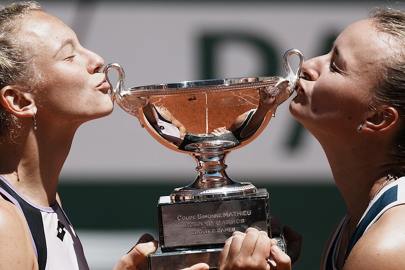 Czech Republic's Barbora Krejcikova, right, and compatriot Katerina Siniakova kiss the cup after defeating USA's Bethanie Mattek-Sands and Poland's Iga Swiatek in their women's doubles final match of the French Open tennis tournament at the Roland Garros stadium Sunday, June 13, 2021 in Paris. (AP Photo/Thibault Camus)
