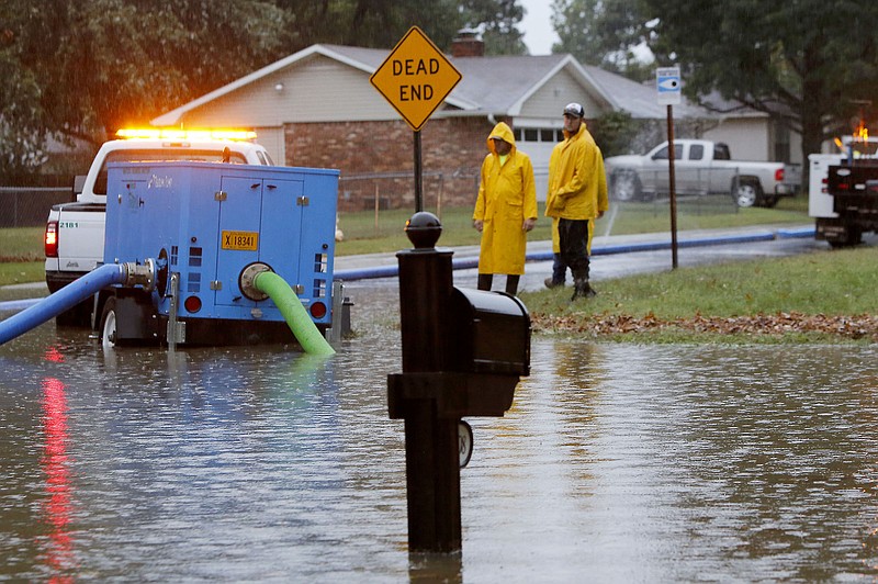 City of Fayetteville personnel were clearing a storm drain to allow the water to recede near the intersection of Clover Drive and Eden Circle in Fayetteville Monday October 13, 2014. (NWA Democrat-Gazette File Photo/DAVID GOTTSCHALK)