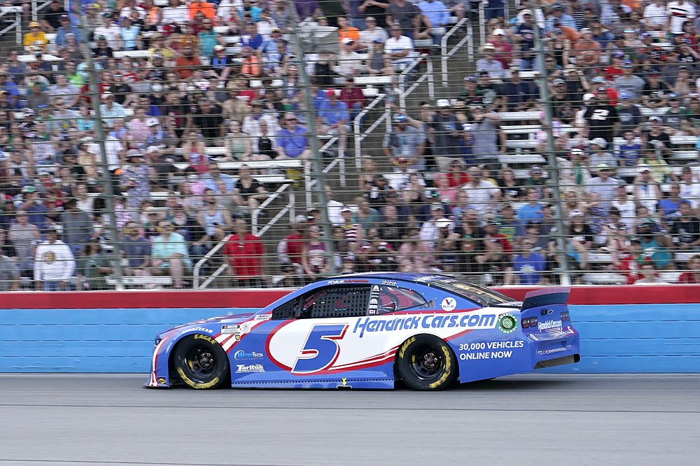 Fans look on as Kyle Larson comes out of Turn 4 during the NASCAR Cup Series All-Star auto race at Texas Motor Speedway in Fort Worth, Texas, Sunday, June 13, 2021. (AP Photo/Tony Gutierrez)