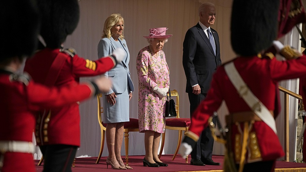 US President Joe Biden and First Lady Jill Biden stand with Britain's Queen Elizabeth II watching a Guard of Honour march past before their meeting at Windsor Castle near London, Sunday, June 13, 2021. (AP Photo/Matt Dunham, Pool)