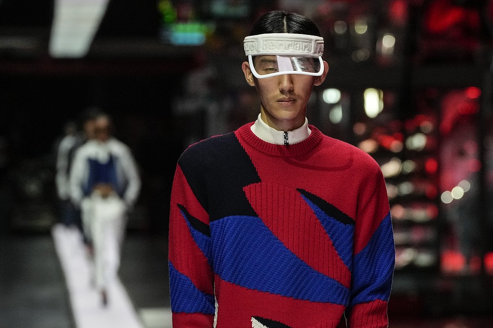 A model wears a creation as part of the Ferrari women's and men's Spring Summer 2022 collection, in Maranello, Italy, Sunday, June 13, 2021. (AP Photo/Antonio Calanni)