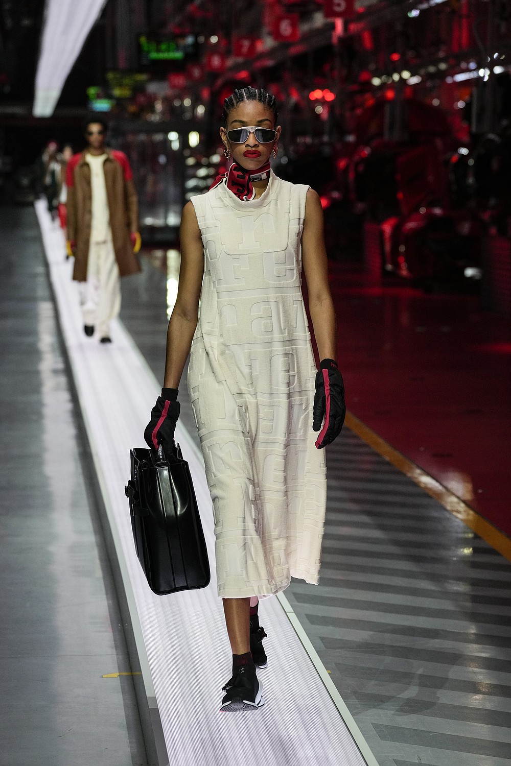 A model wears a creation as part of the Ferrari women's and men's Spring Summer 2022 collection, in Maranello, Italy, Sunday, June 13, 2021. (AP Photo/Antonio Calanni)