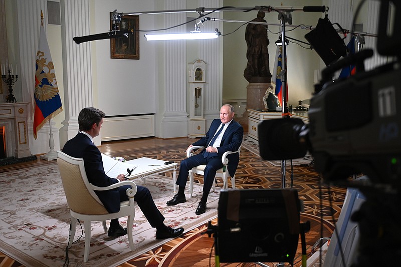 Russian President Vladimir Putin speaks to NBC News journalist Keir Simmons, back to a camera, in an interview aired on Monday, June 14, 2021, two days before the Russian leader is to meet U.S. President Joe Biden in Geneva. Putin has sharply dismissed allegations that his country is carrying out cyberattacks against the United States as baseless. (Maxim Blinov, Sputnik, Kremlin Pool Photo via AP)