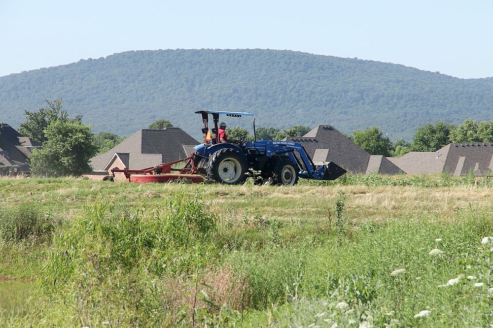 LYNN KUTTER ENTERPRISE-LEADER
Floyd Shelley, Farmington public works manager, brush hogs grass at Valley View golf course last week. Three employees spent two days mowing the grass on the property.