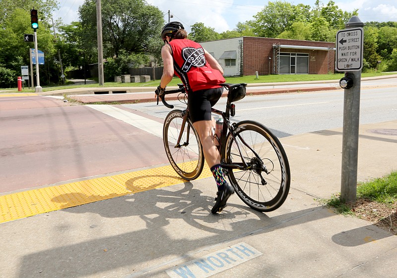 FILE -- Michele Smith pushes off into her peddles Friday, June 11, 2021, after waiting for the light to change to cross W. North Street in Fayetteville. 
(NWA Democrat-Gazette/David Gottschalk)
