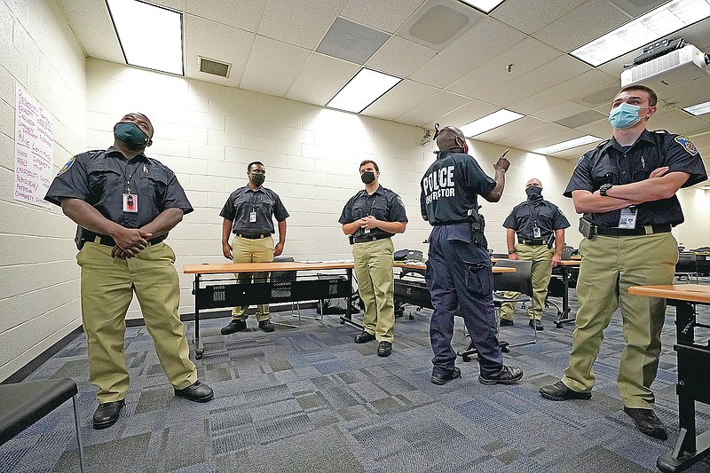 In this Sept. 9, 2020, photo Officer Edward Gillespie, third from right, leads a class in procedural justice with Baltimore Police Academy cadets in Baltimore. (AP Photo/Julio Cortez)