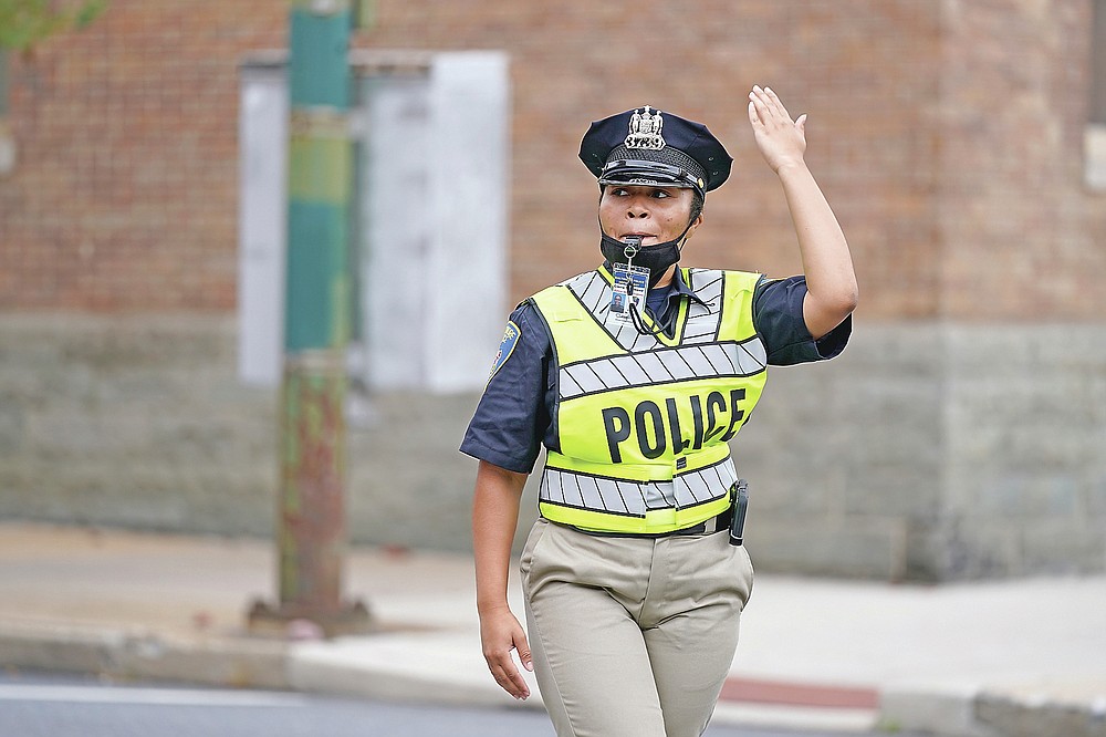 In this Sept. 9, 2020, photo Cierra Thurmond, a cadet in the Baltimore Police Academy, directs traffic during an on the field class session in Baltimore. (AP Photo/Julio Cortez)