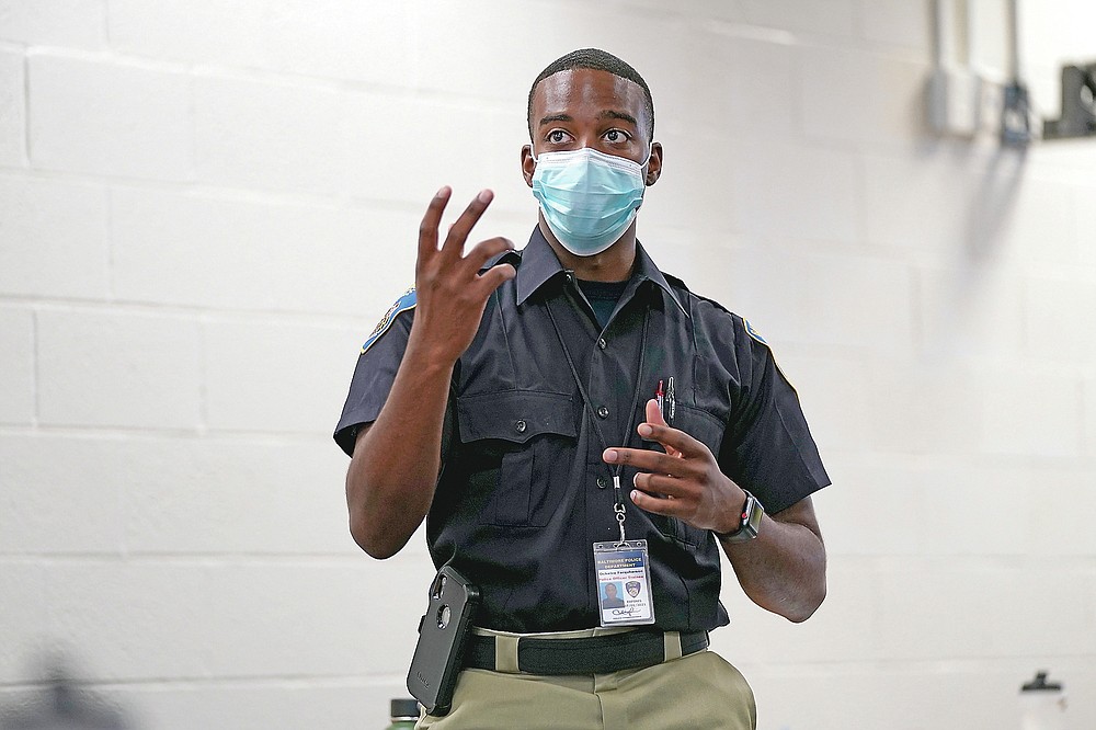 In this Sept. 9, 2020, photo Ockeive Farquharson, a cadet in the Baltimore Police Academy, reacts to a video presentation during a class focusing on procedural justicein Baltimore. (AP Photo/Julio Cortez)