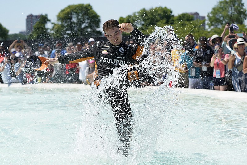 Pato O'Ward celebrates by jumping into James Scott Memorial Fountain Sunday after winning the second race of the IndyCar Detroit Grand Prix doubleheader on Belle Isle in Detroit. - Photo by Paul Sancya of The Associated Press