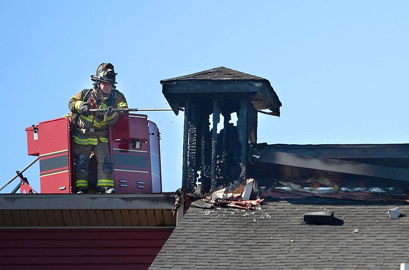 Fayetteville firefighters work Tuesday on the roof after a fire broke out at Village at Shiloh Park Land apartments in Fayetteville. Visit nwaonline.com/210616Daily/ for today's photo gallery.
(NWA Democrat-Gazette/Andy Shupe)