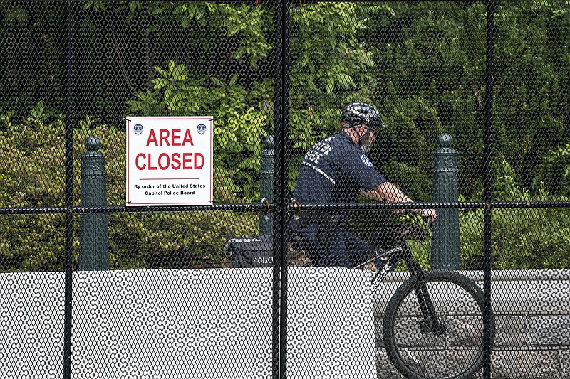 A U.S. Capitol Police officer patrols the barricaded perimeter of the Capitol grounds in Washington, Monday, June 14, 2021. (AP Photo/J. Scott Applewhite)