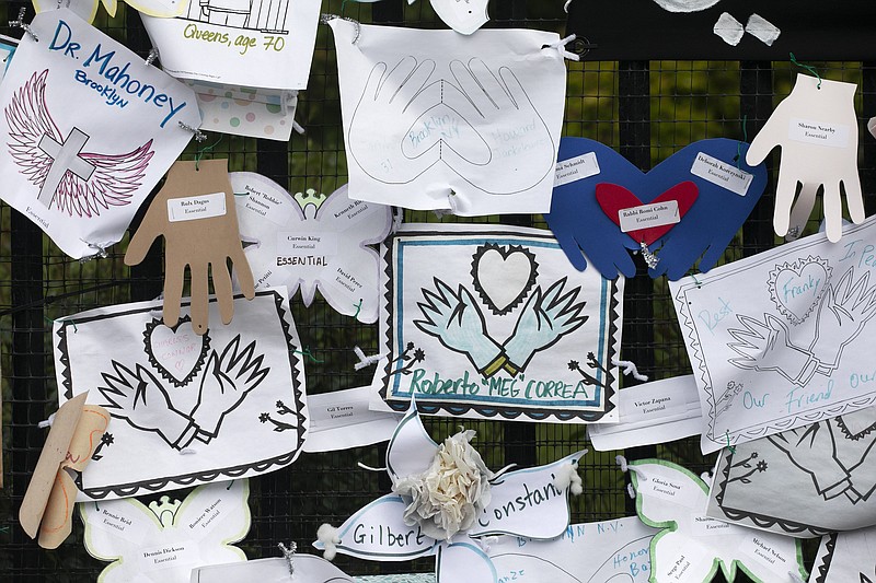FILE - In this May 28, 2020, file photo, Tributes to lost love ones adorn a fence outside Brooklyn's Green-Wood Cemetery where many victims of COVID-19 are buried in New York. The U.S. death toll from COVID-19 has topped 600,000, even as the vaccination drive has drastically slashed daily cases and deaths and allowed the country to emerge from the gloom. (AP Photo/Mark Lennihan, File)