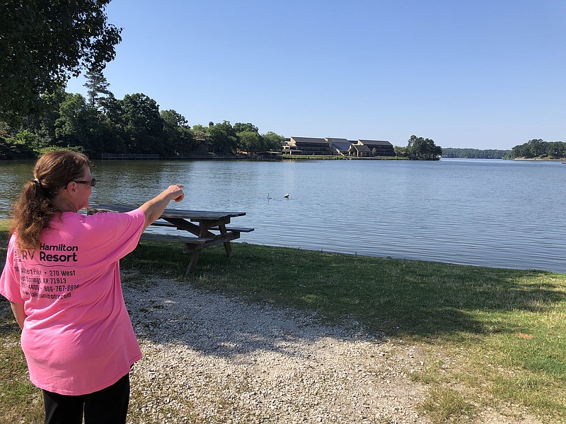 Twyla Arquette points to where an alligator was seen at the Lake Hamilton Resort RV park in the water. Photo by Krishnan Collins of The Sentinel-Record