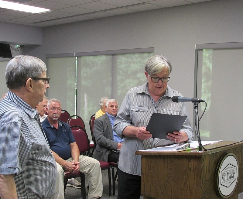 From left, Larry Wilson, executive director of the Arkansas Heritage Festival, listens as Hot Springs Village POA board chair JoAnne Corry reads the Arkansas Heritage proclamation. - Submitted photo