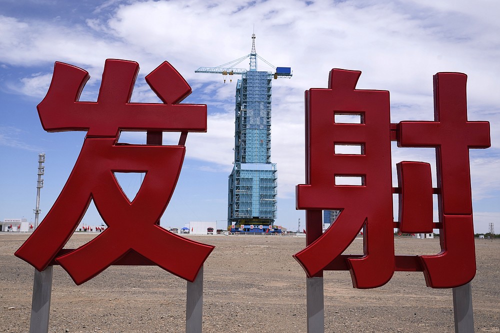 The Shenzhou-12 spacecraft sits covered on a launch pad near Chinese characters reading "Launch" at the Jiuquan Satellite Launch Center near Jiuquan, China on Wednesday, June 16, 2021. China plans to launch three astronauts onboard the Shenzhou-12 spacecraft, who will be the first crew members to live on China's new orbiting space station Tianhe, or Heavenly Harmony, from the Jiuquan Satellite Launch Center in northwest China. (AP Photo/Ng Han Guan)