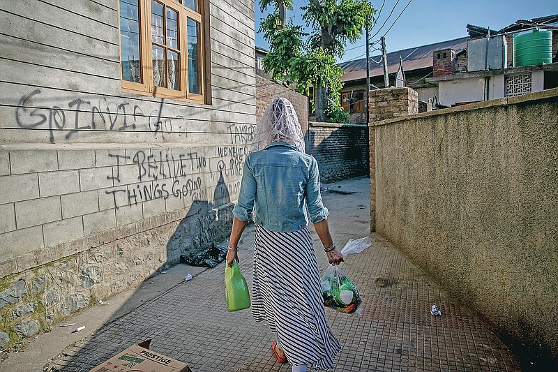 Sabu Sheikh, a transgender Kashmiri, walks homeward after collecting food handouts in Srinagar, Indian controlled Kashmir, Thursday, May 27, 2021. Kashmir's  transgender are often only able to find work as matchmakers or wedding entertainment. Prolonged coronavirus lockdowns, preceded by a strict security lockdown in the region in 2019 when India scrapped Kashmir's semi-autonomous status, left many in the transgender community with no work at all. (AP Photo/ Dar Yasin)