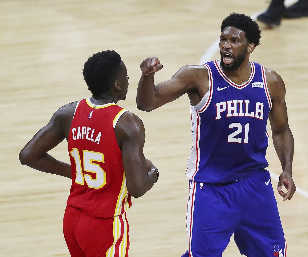 Philadelphia 76ers center Joel Embiid, right, makes a point to Atlanta Hawks center Clint Capela during the first half of Game 5 of an NBA basketball Eastern Conference semifinal Wednesday, June 16, 2021, in Philadelphia. (Curtis Compton/Atlanta Journal-Constitution via AP)